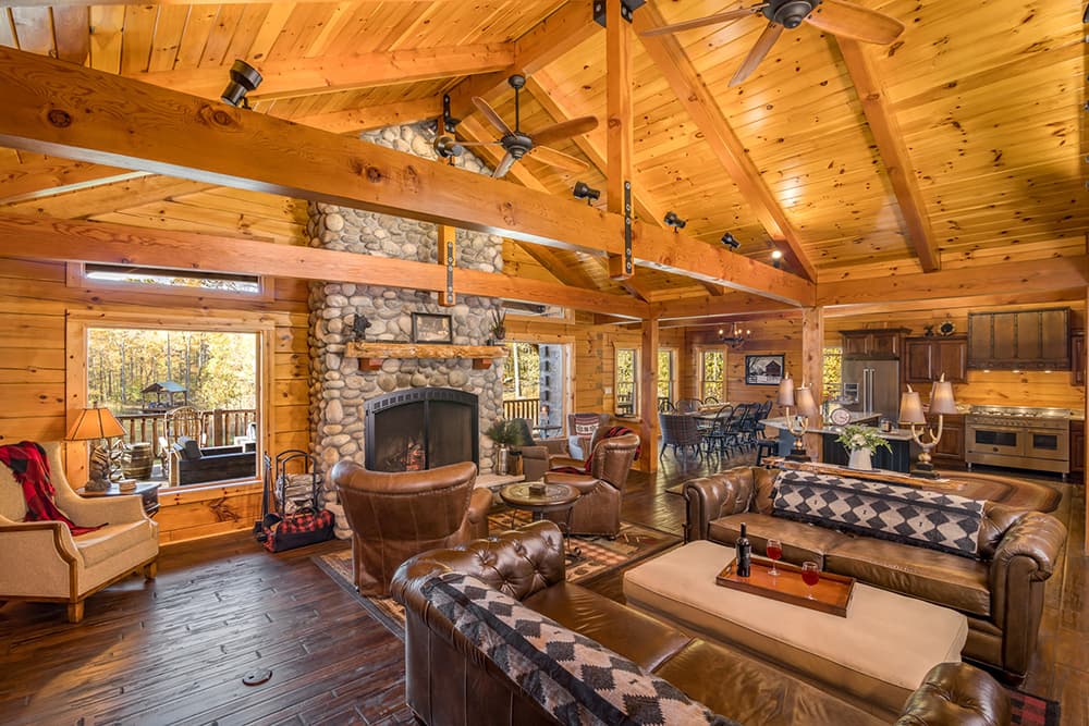 The interior view of a wooden ceiling featuring exposed beams and light fixtures. The warm tones of the wood highlight the craftsmanship, showcasing the beauty of log homes and custom homes.
