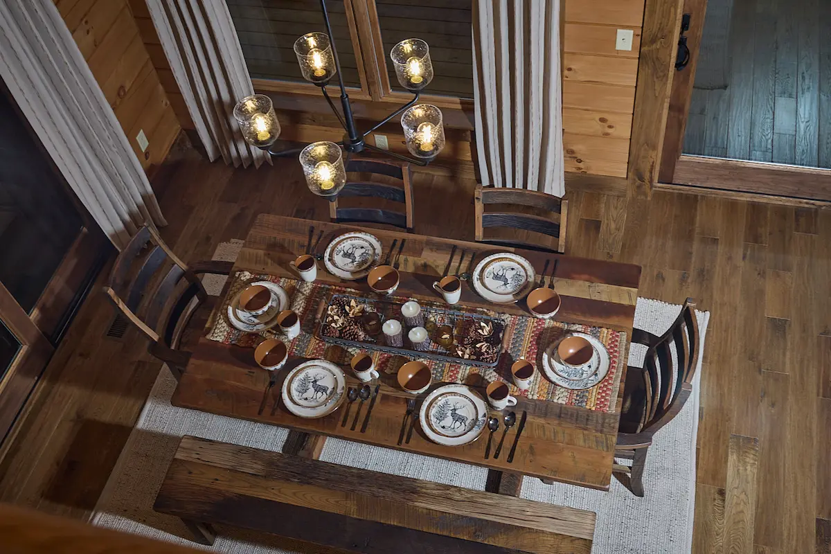 The interior view of a wooden ceiling featuring exposed beams and light fixtures. The warm tones of the wood highlight the craftsmanship, showcasing the beauty of log homes and custom homes.