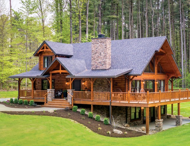 Hochstetler Spec Home in Perrysville, Ohio, featuring log construction, a stone chimney, timbered gables, and a wraparound deck.