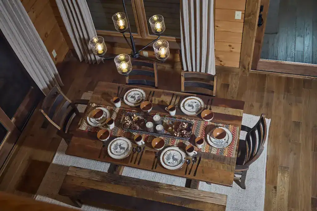 Rustic dining room with wooden table and chairs in Hochstetler Log Homes.