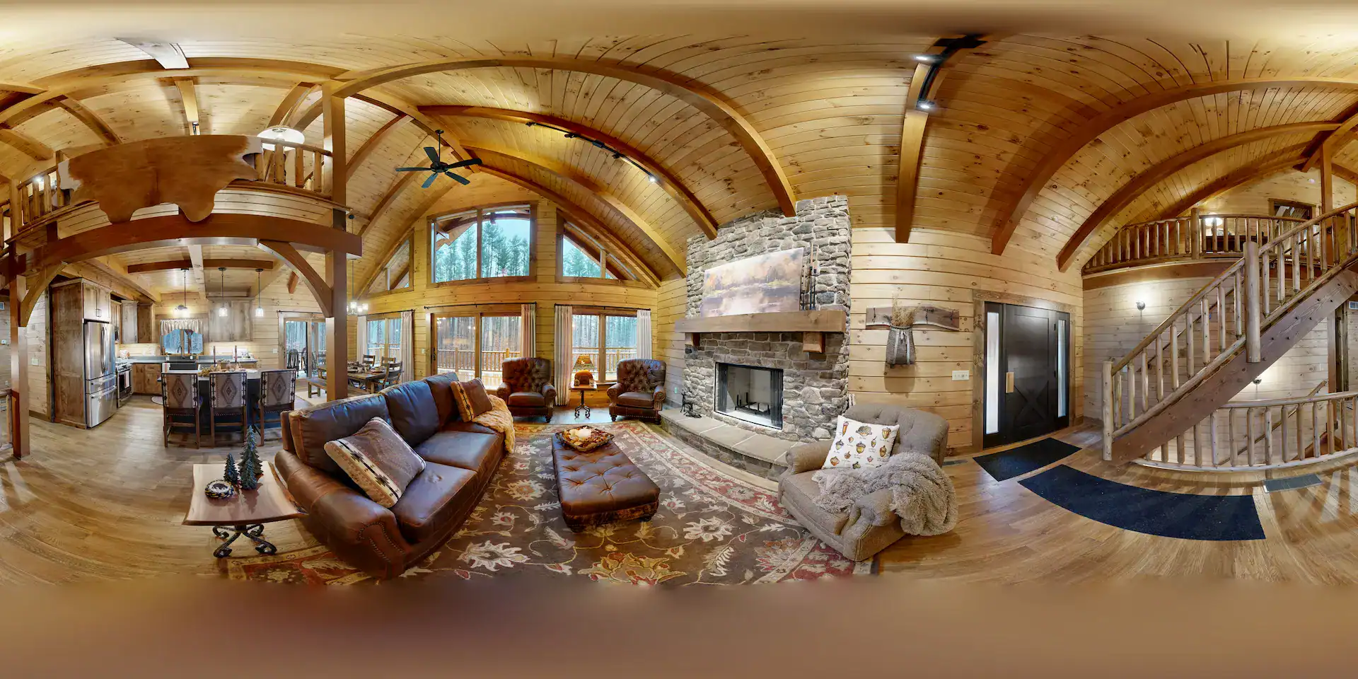 Warm log home living room with large windows and rustic decor.