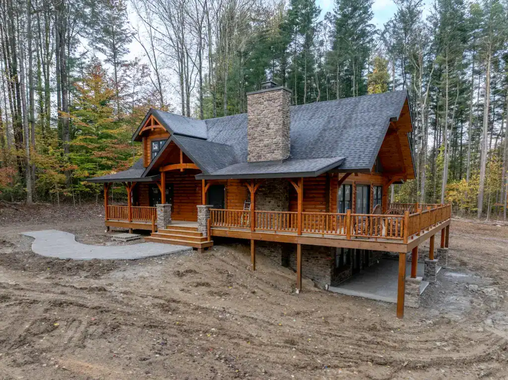 Completed log home exterior with porches and grading near completion